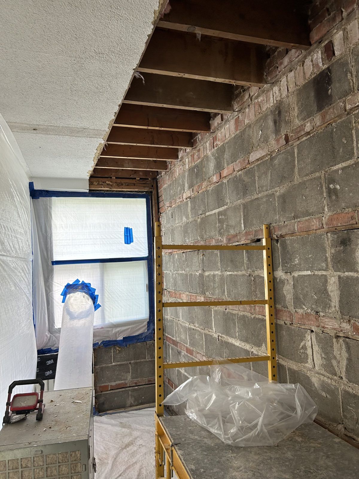 Sealed work area: textured ceiling opened to the joists, HEPA air scrubber and scaffolding